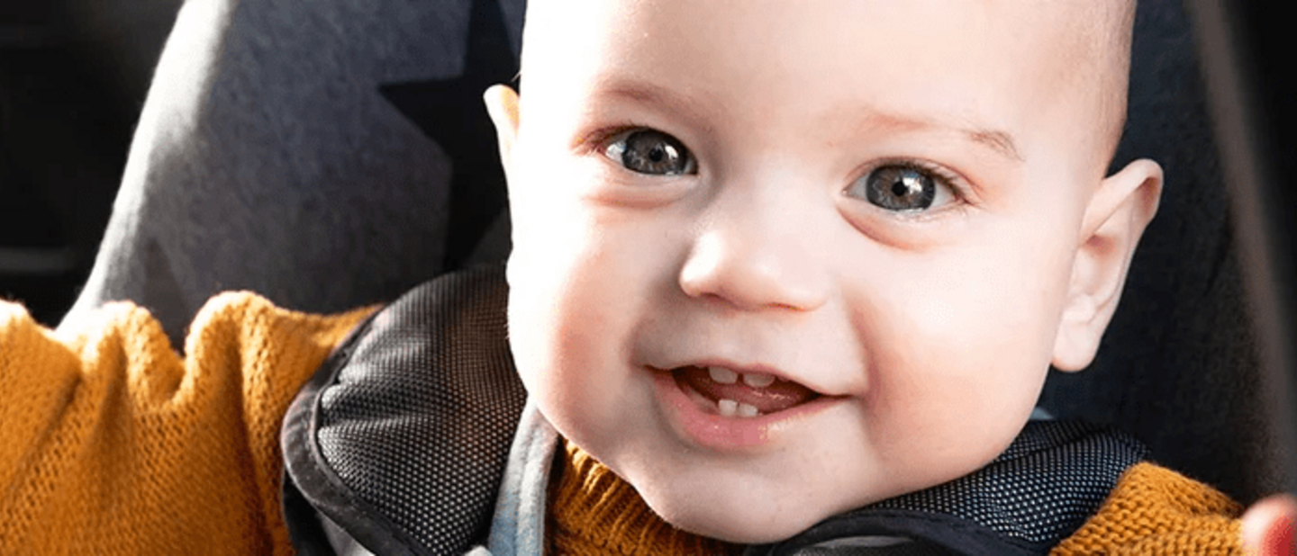 Lachende baby in autostoel