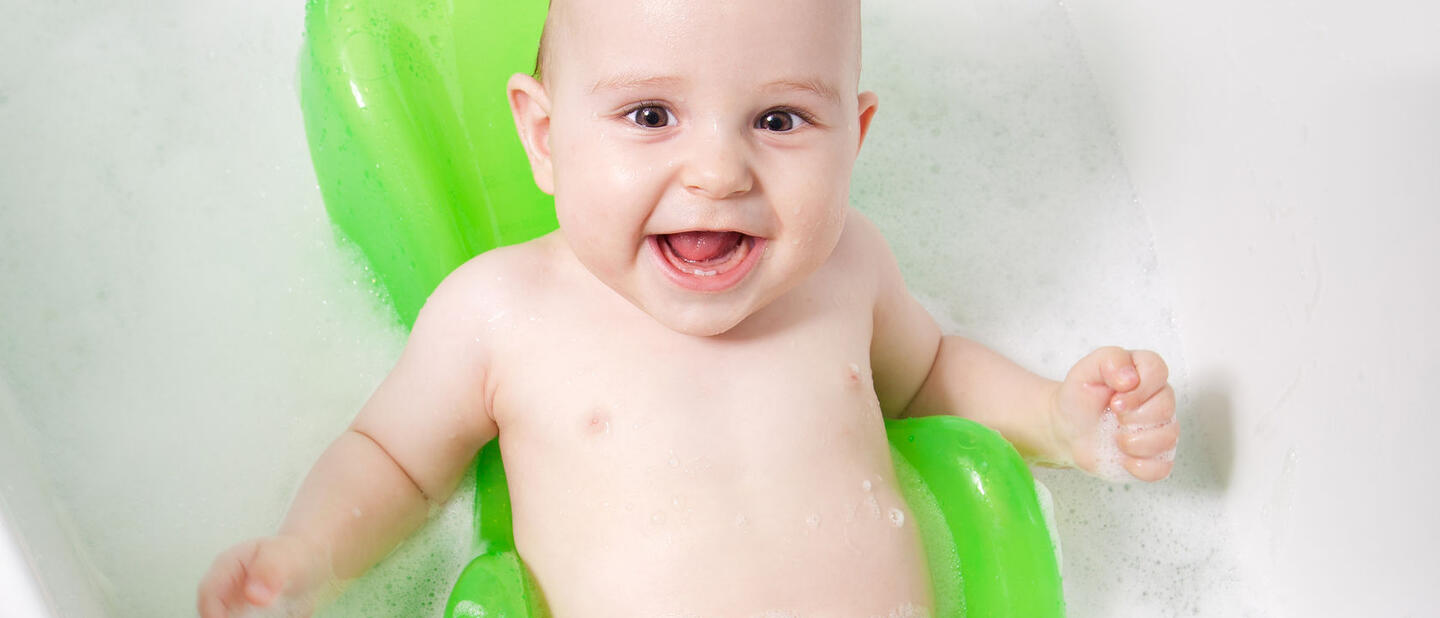 Baby in een badzitje in bad