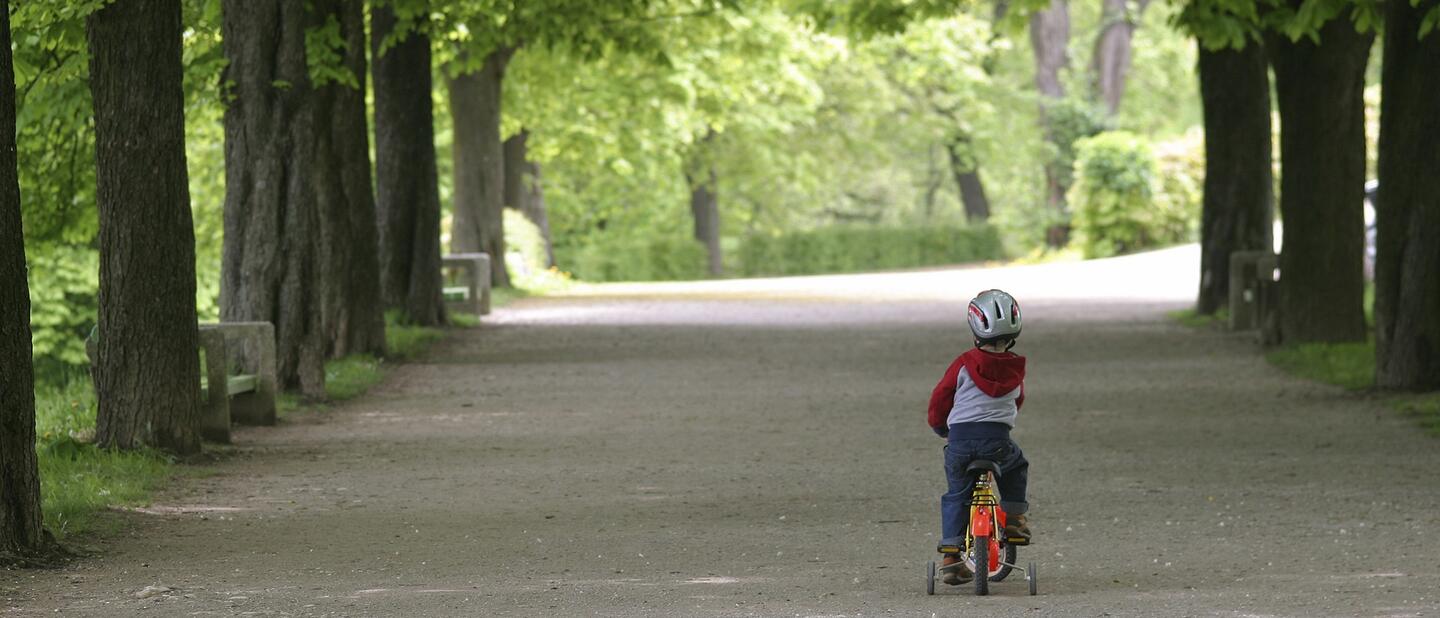 Jong kind dat leert fietsen met zijwieltjes