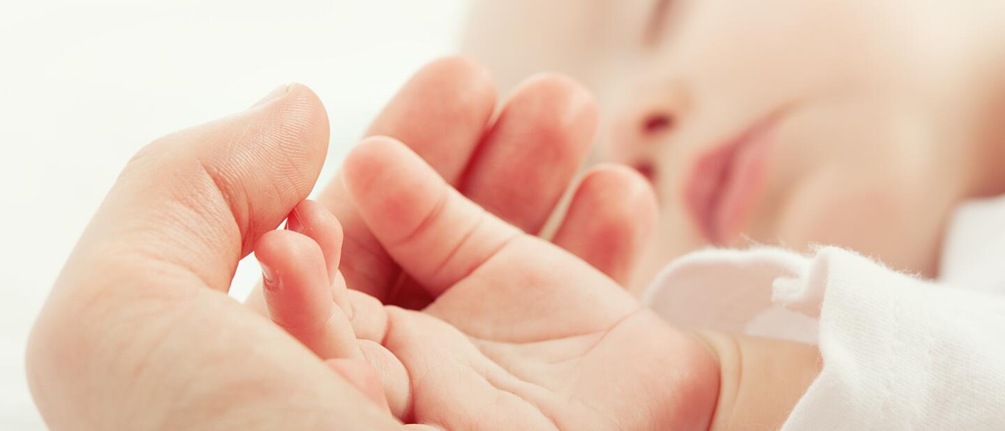 Veilig slapen - Baby slaapt met hand moeder