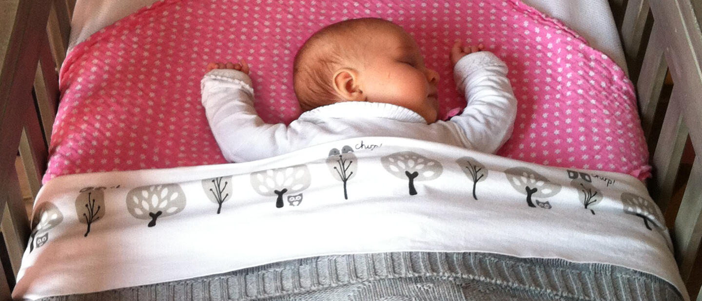 Baby in kort opgemaakt bedje