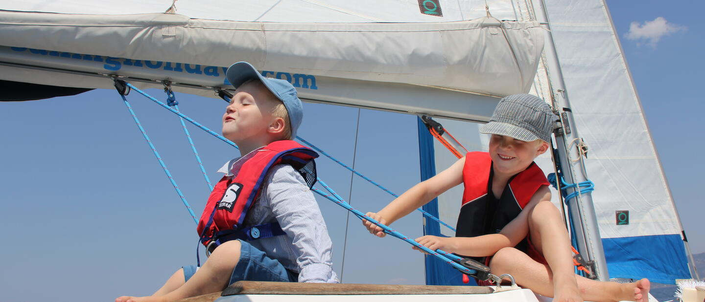 Jongetjes op zeilboot met reddingsvest
