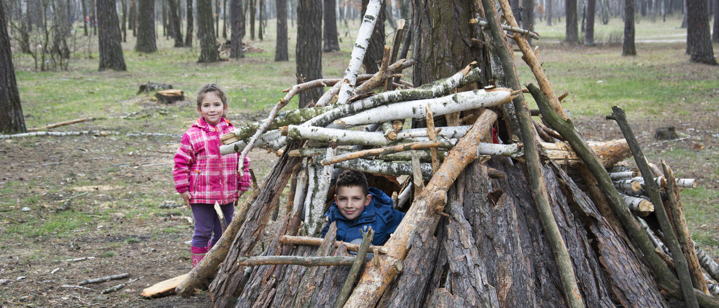 Kinderen spelen in hut in bos