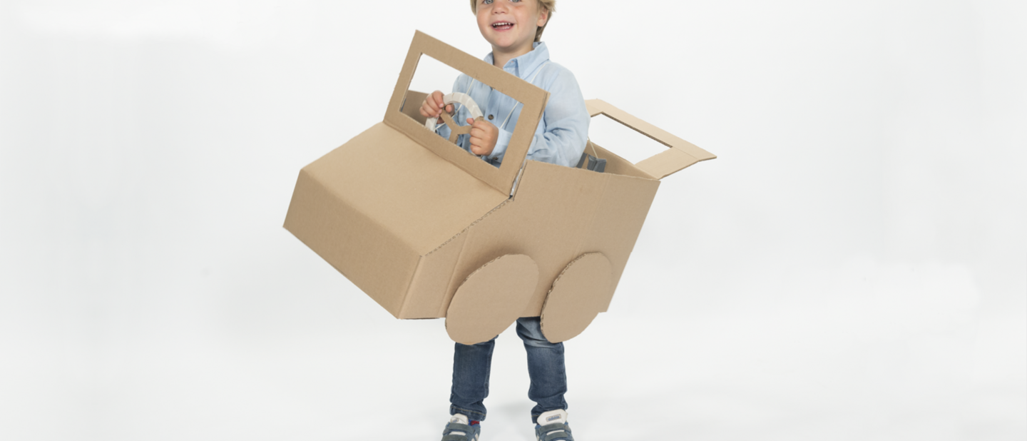 Jongetje in auto van karton - staand