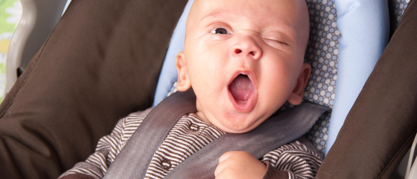 Gapende baby in autostoel