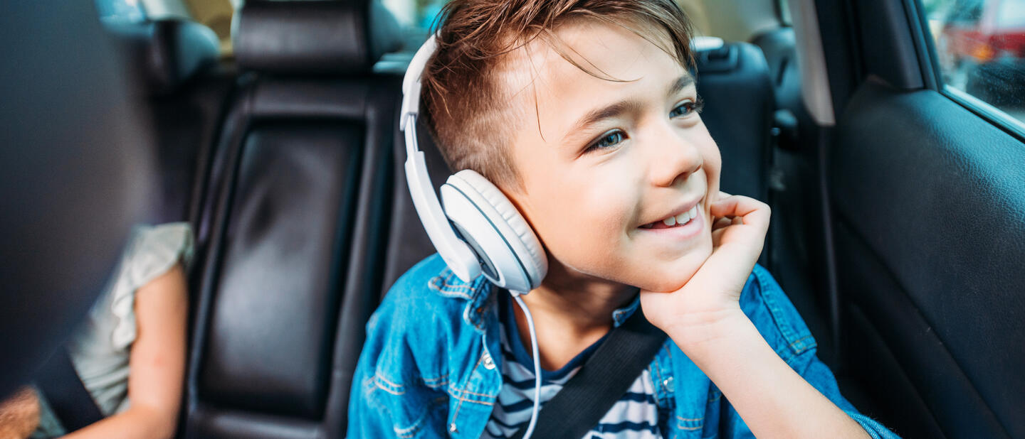 Jongetje met koptelefoon in auto